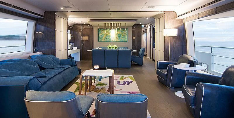 a living room with a blue couch and a table aboard MEMORIES TOO Yacht for Sale