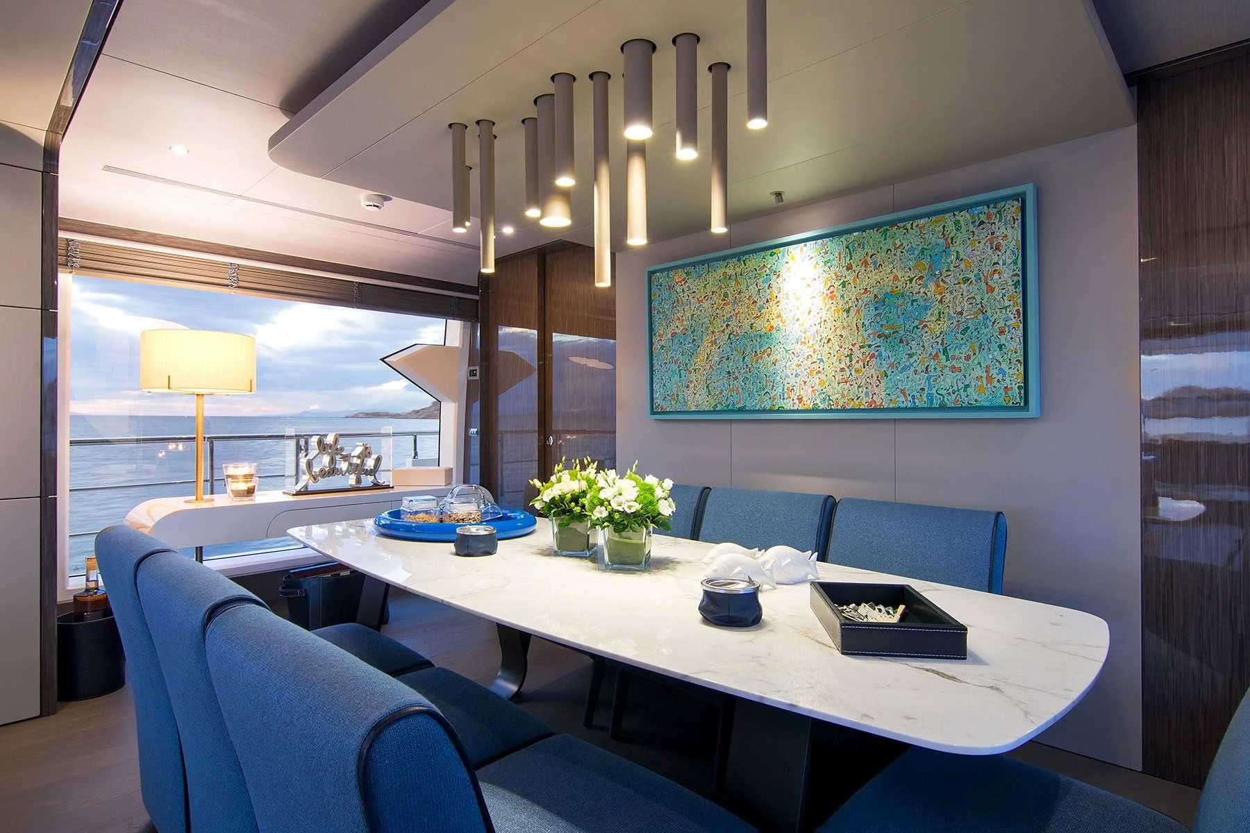 a room with a table chairs and a painting on the wall aboard MEMORIES TOO Yacht for Sale