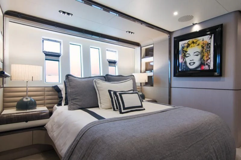 a bed with a painting on the wall aboard MEMORIES TOO Yacht for Sale