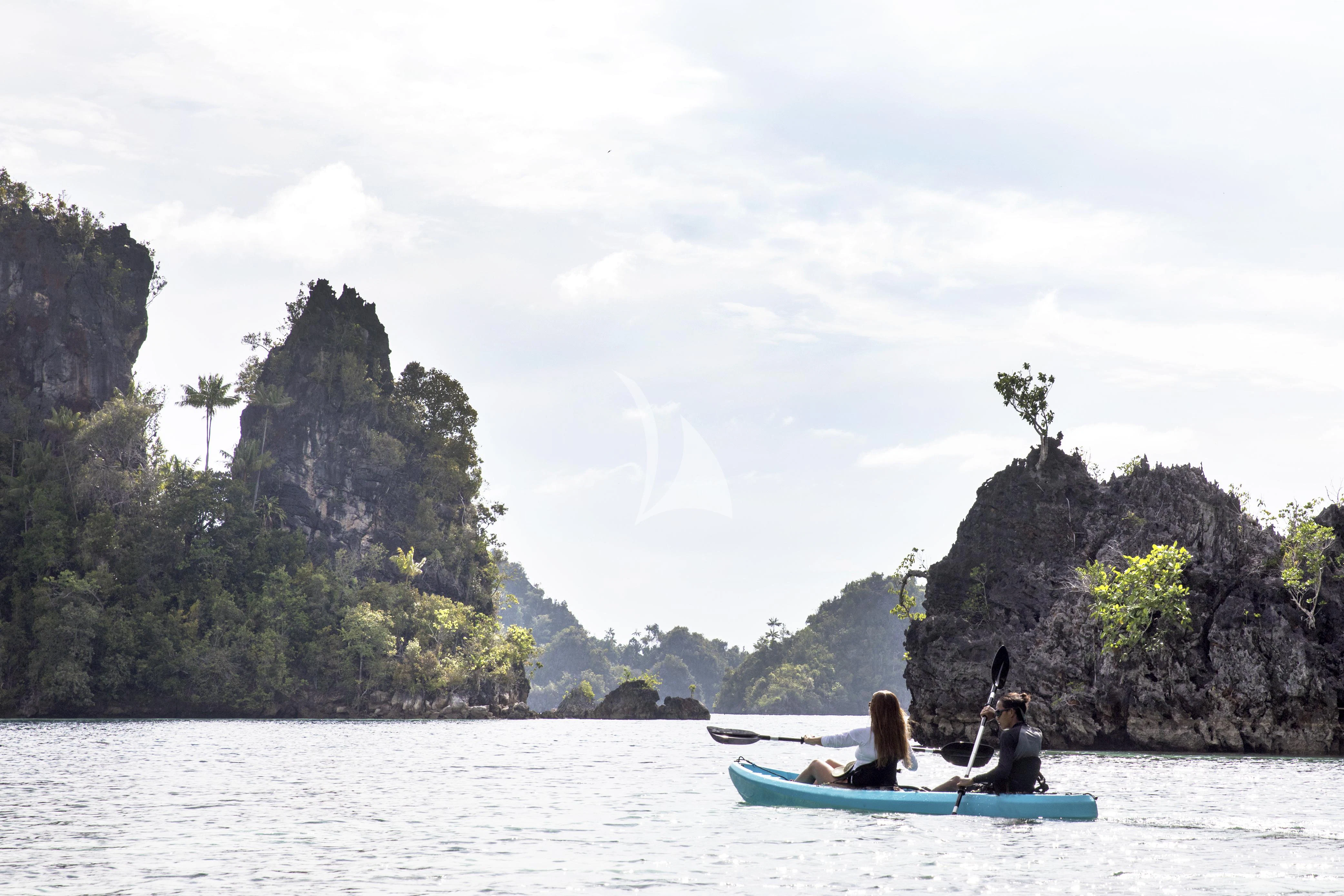 a couple people in a canoe in the water by a cliff aboard AQUA BLU Yacht for Sale