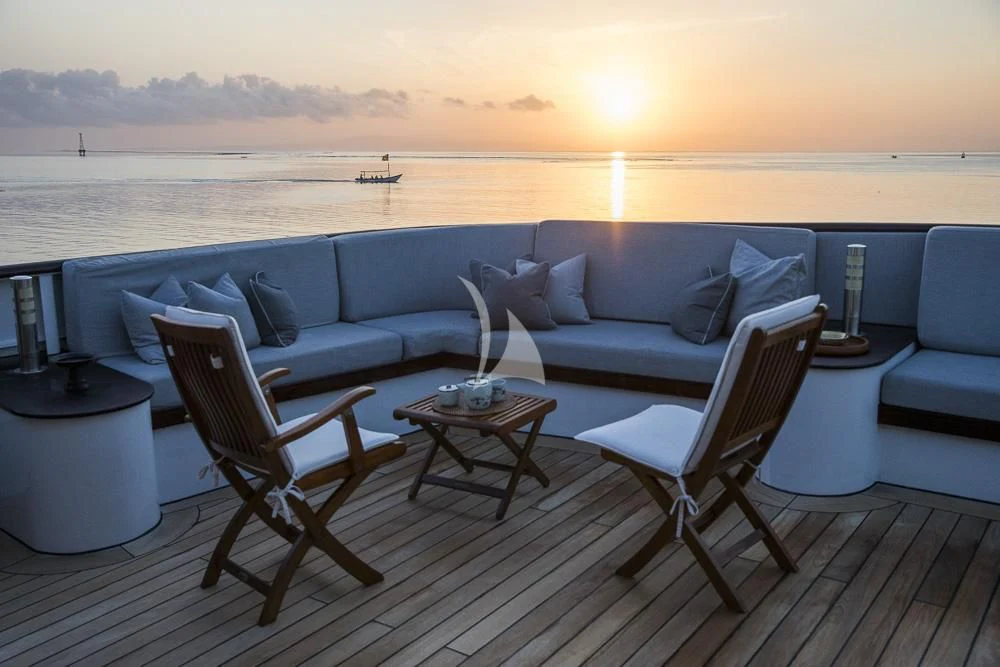a living room with a large body of water and a boat in the distance aboard AQUA BLU Yacht for Sale
