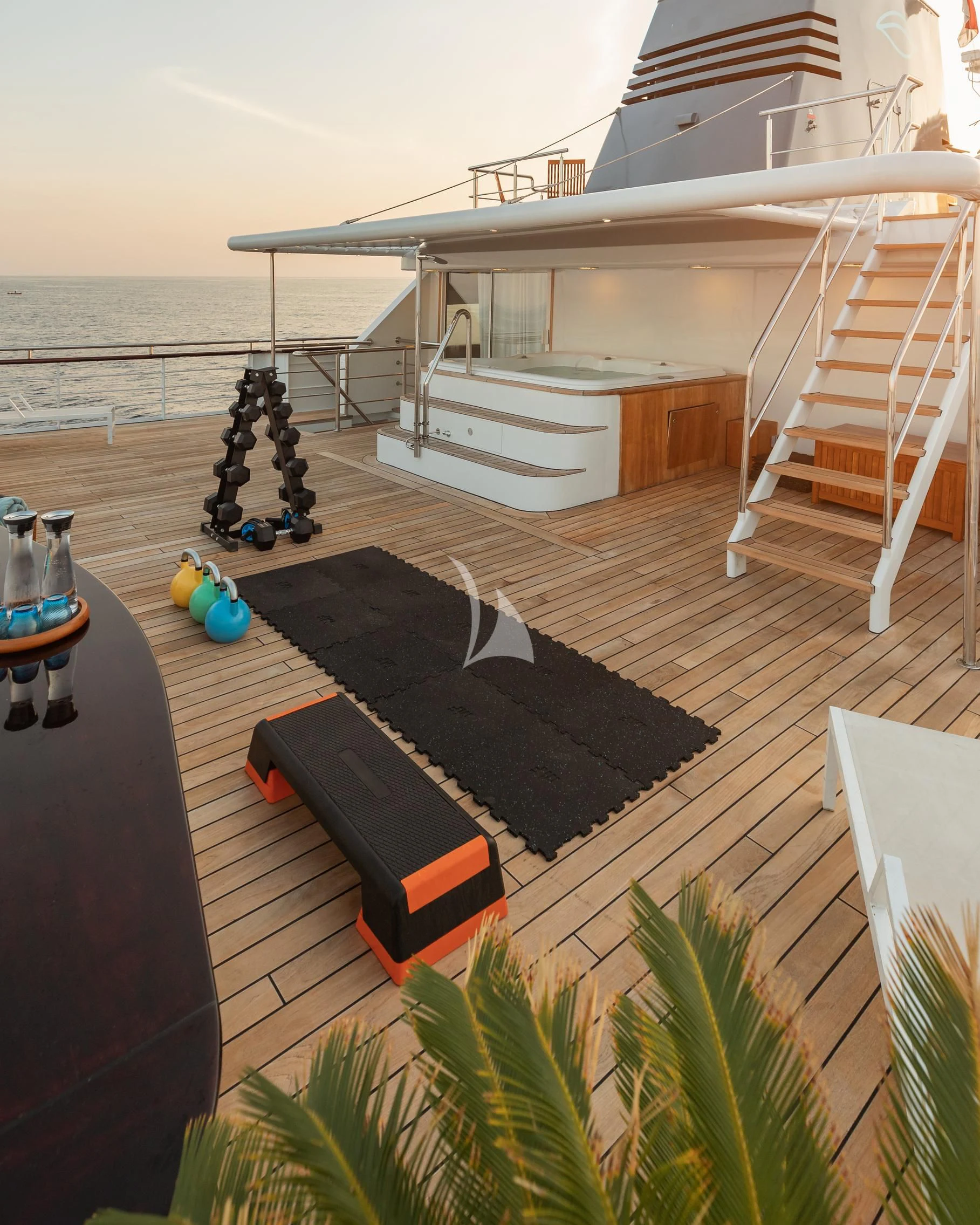 a deck with a slide and a pool and a boat in the water aboard AQUA BLU Yacht for Sale