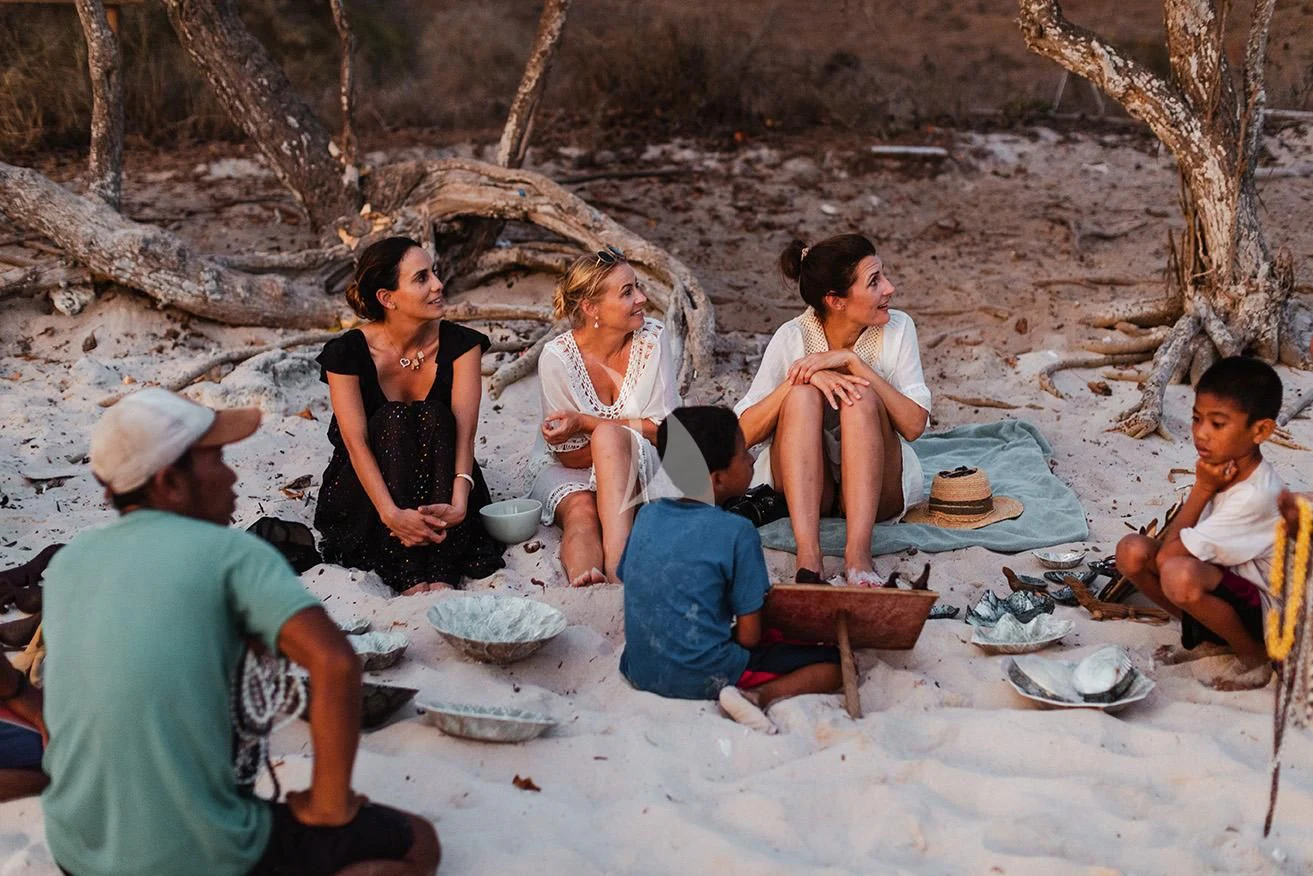a group of people sitting on the sand aboard AQUA BLU Yacht for Sale