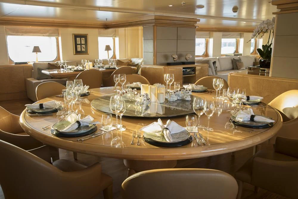 a large dining table with plates and glasses on it aboard AQUA BLU Yacht for Sale