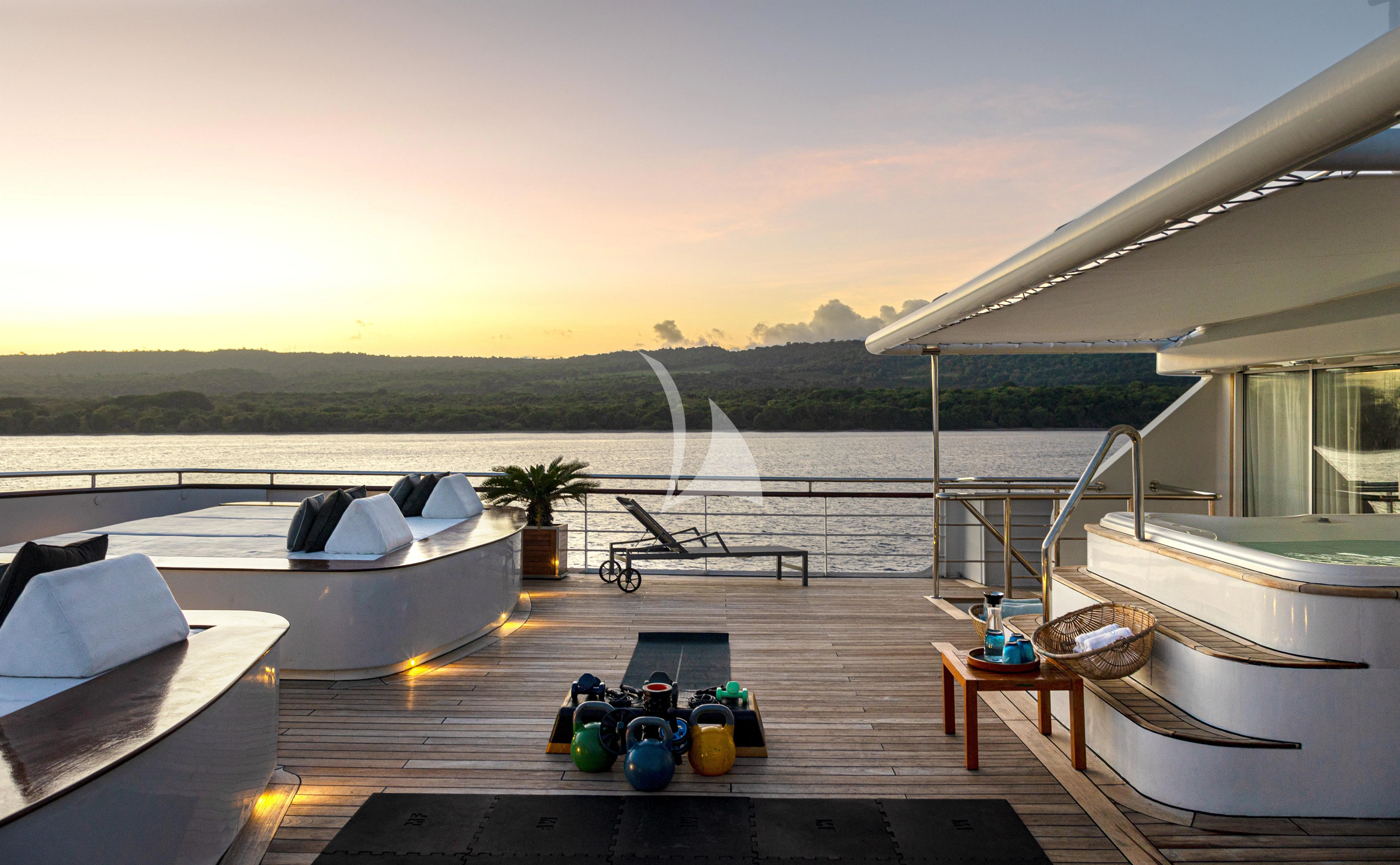 a patio with a fountain and a pool of water and trees in the background aboard AQUA BLU Yacht for Sale