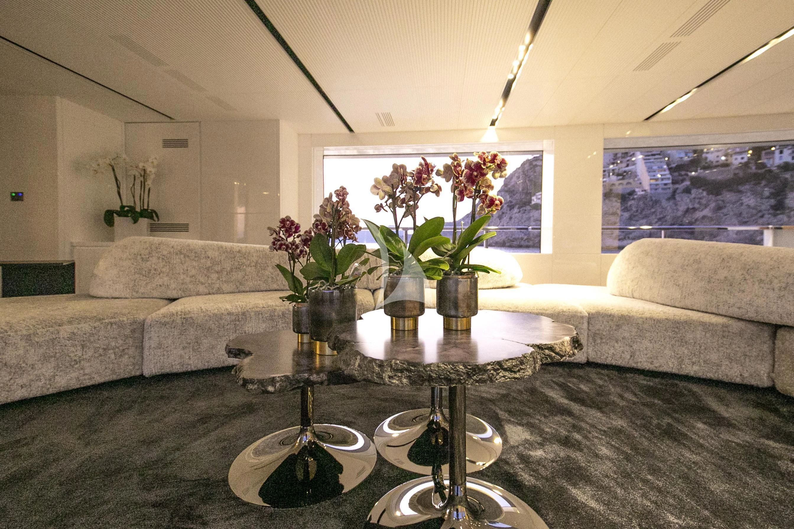 a living room with a table and couches aboard R23 Yacht for Charter