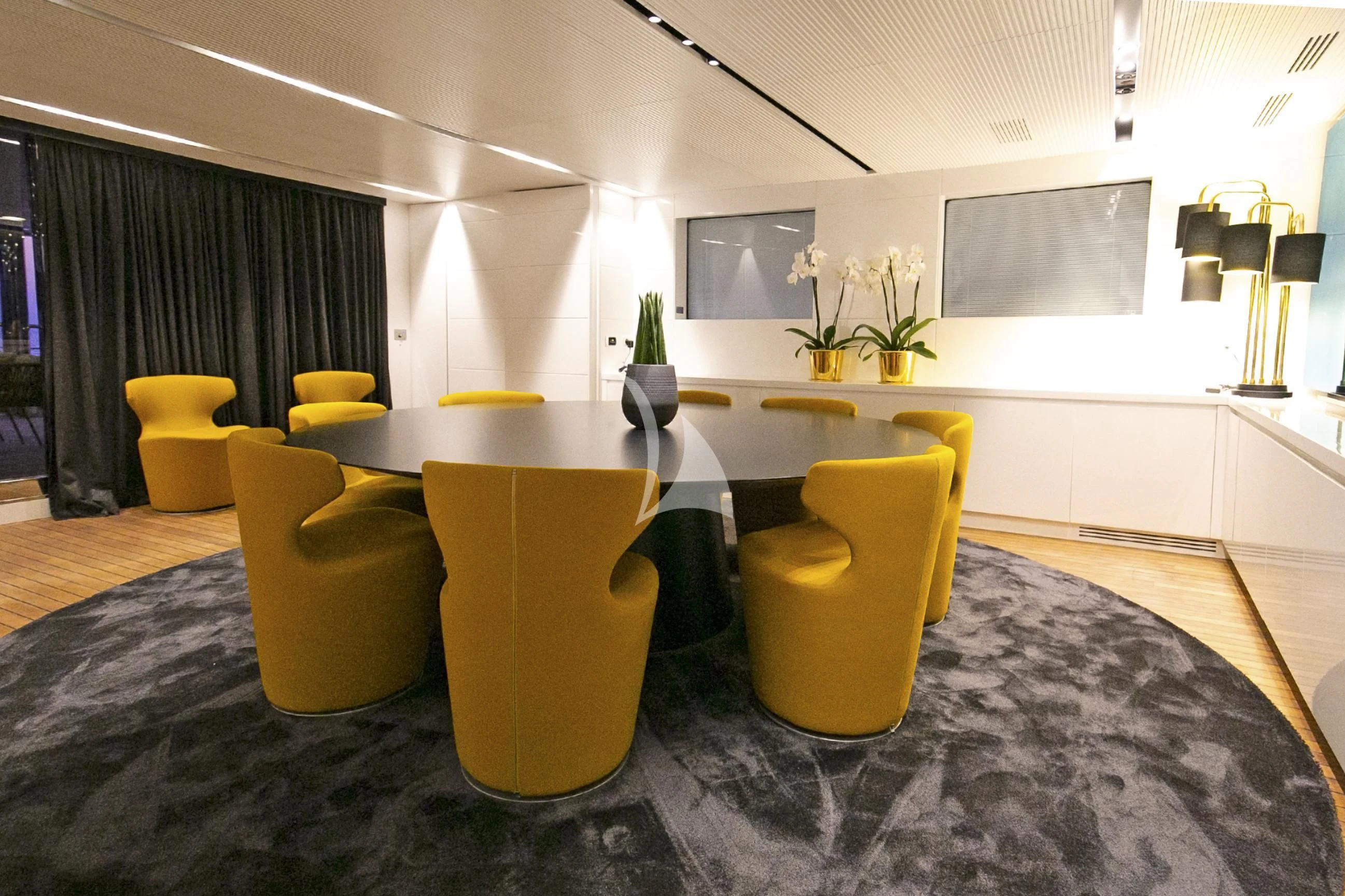 a room with yellow chairs aboard R23 Yacht for Charter