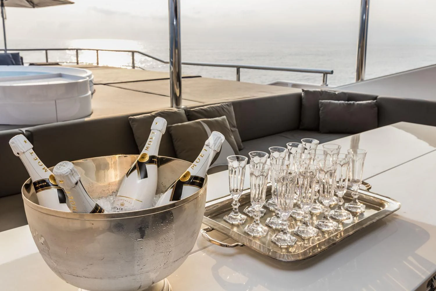 a bowl of champagne and a bottle on a table with a couch and a table with a large aboard R23 Yacht for Charter