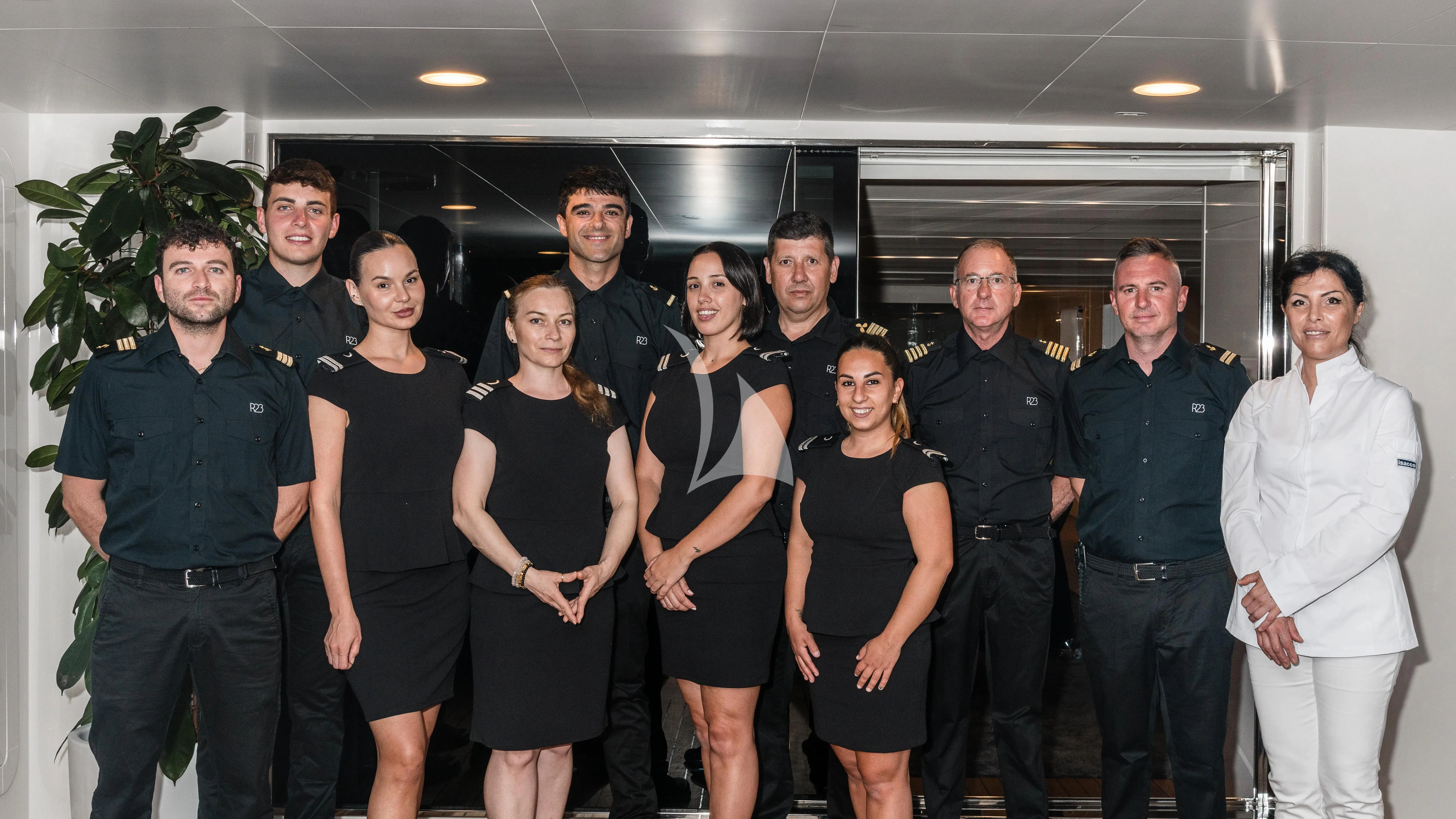 a group of people posing for a photo aboard R23 Yacht for Charter