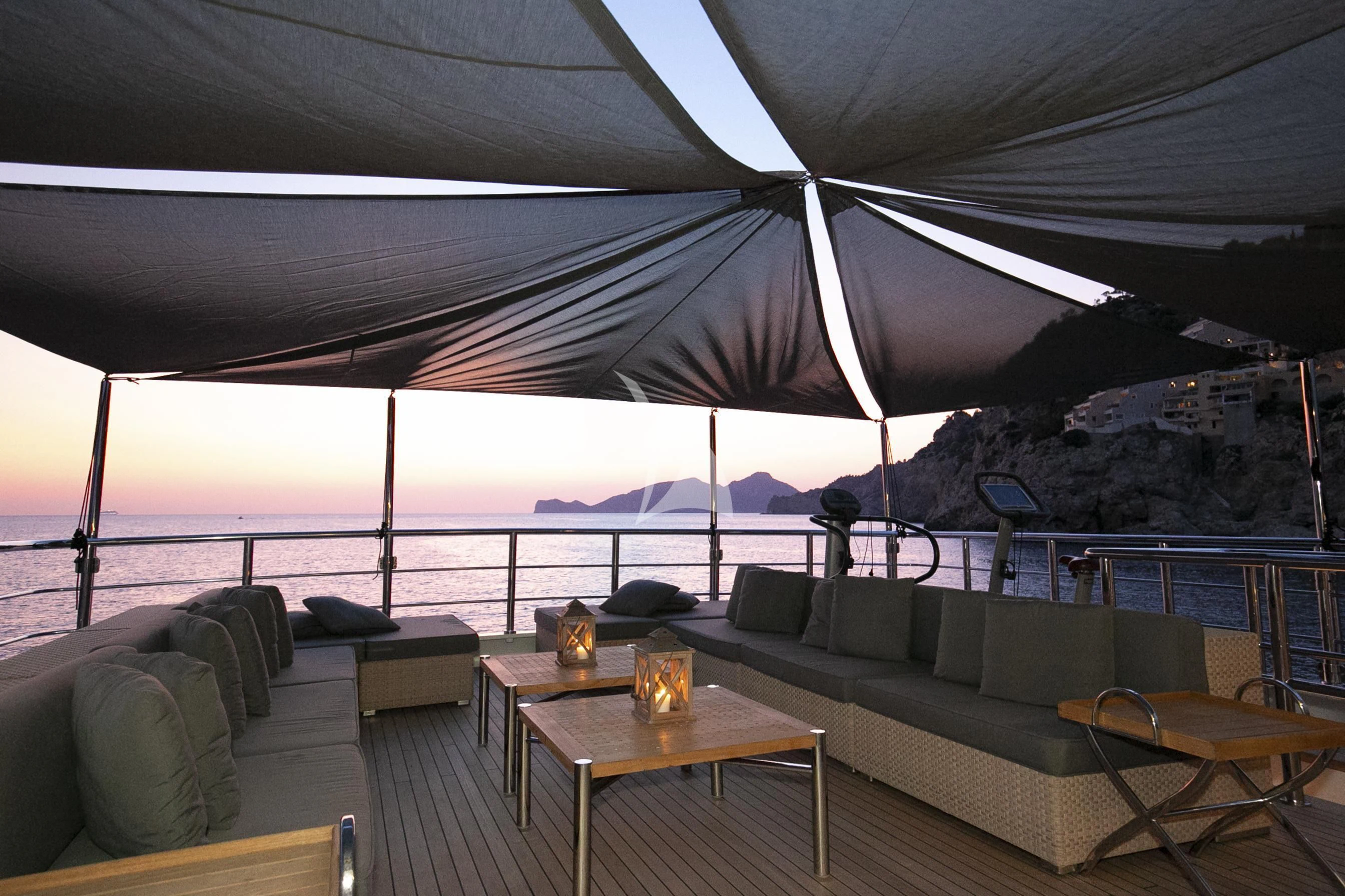 a couch and a table under a tent aboard R23 Yacht for Charter
