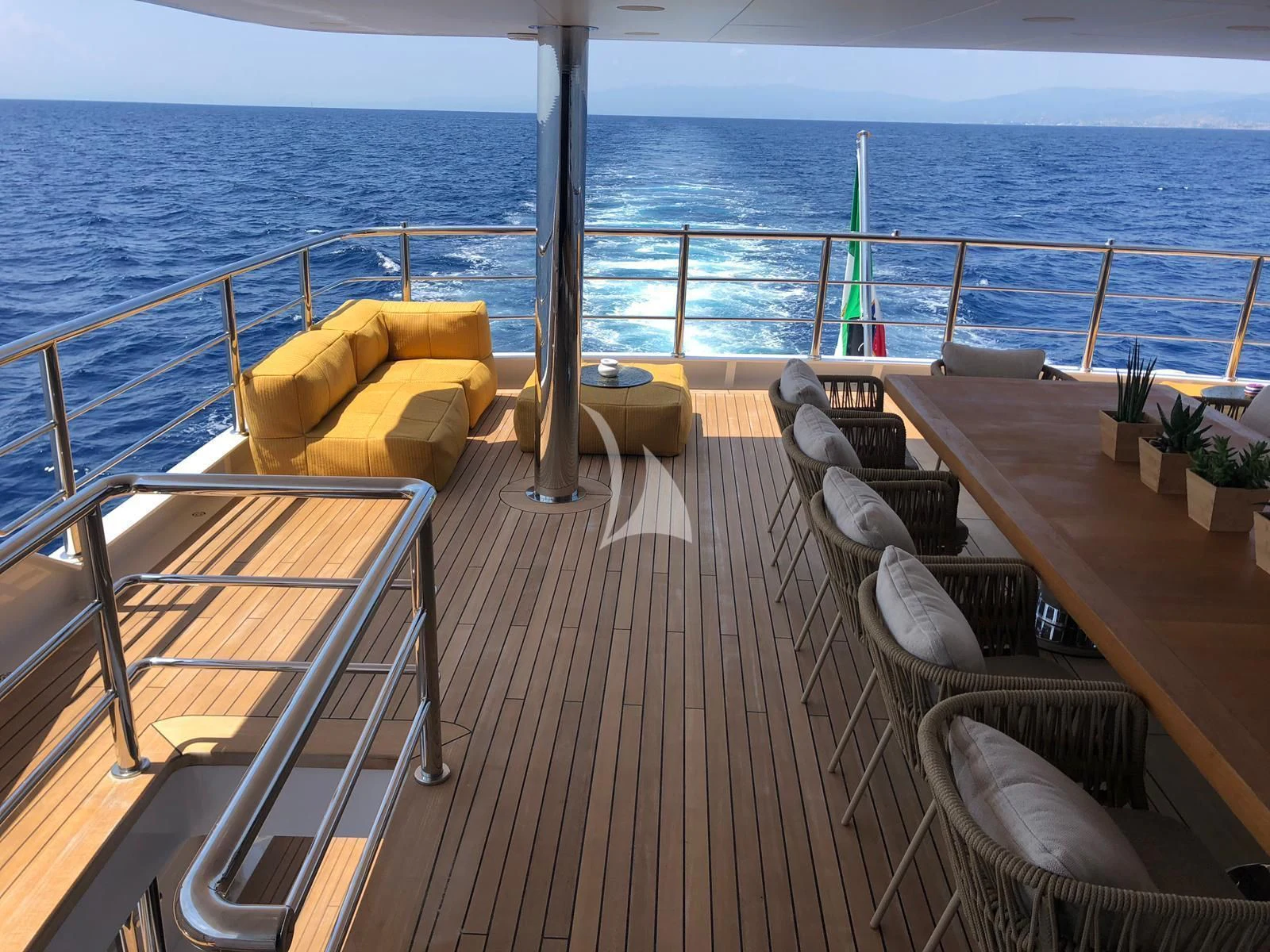 a deck with chairs and a boat aboard R23 Yacht for Charter