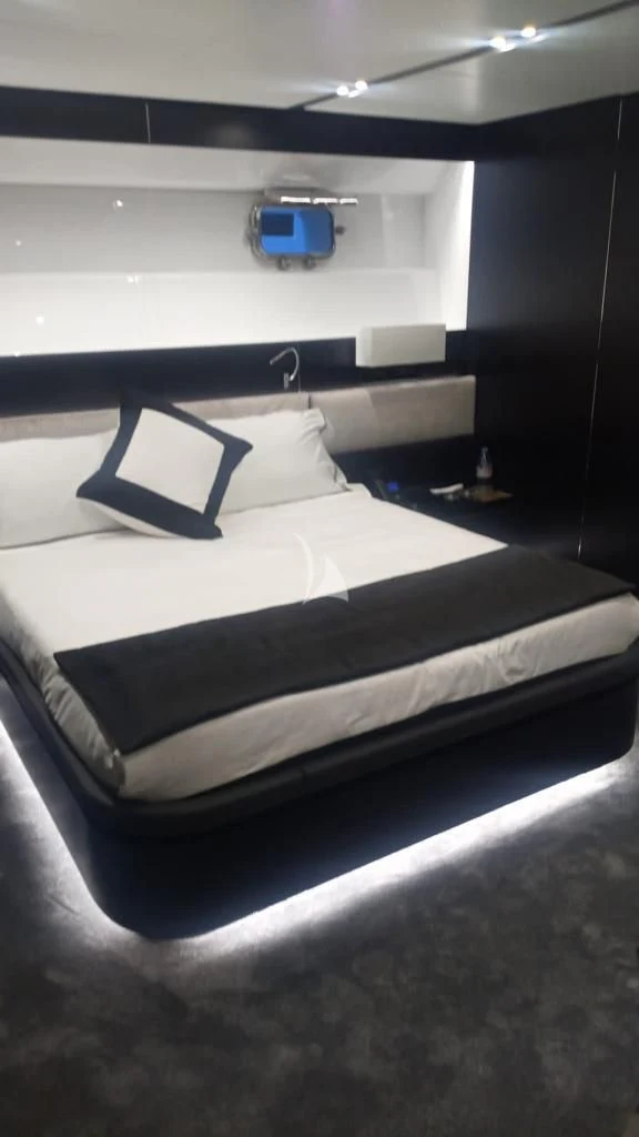 a bed with a black and white bed spread and a blue box on the wall aboard R23 Yacht for Charter