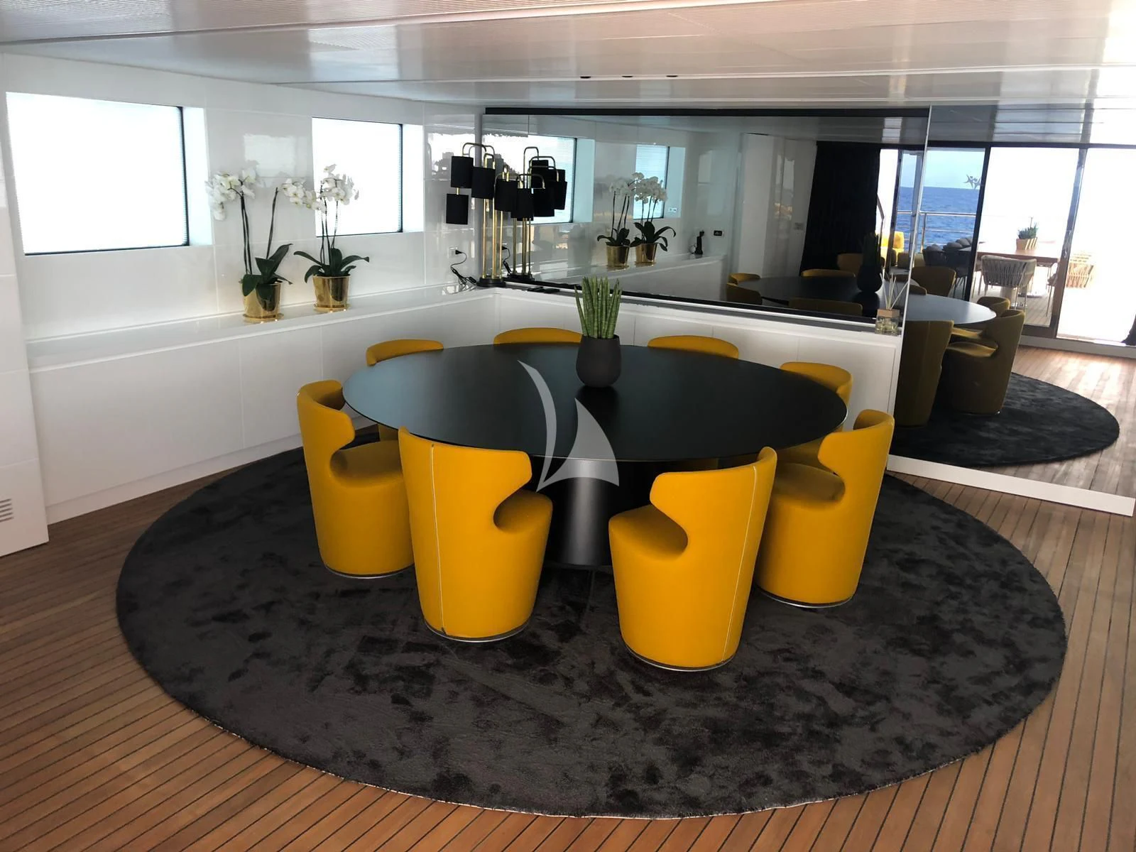 a table with yellow chairs aboard R23 Yacht for Charter
