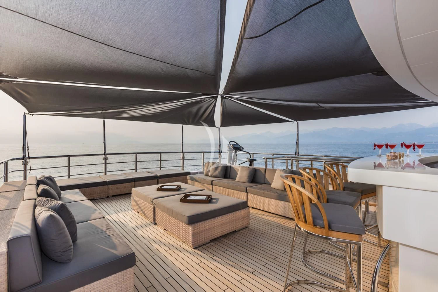 a room with a couch and a table and a large body of water aboard R23 Yacht for Charter