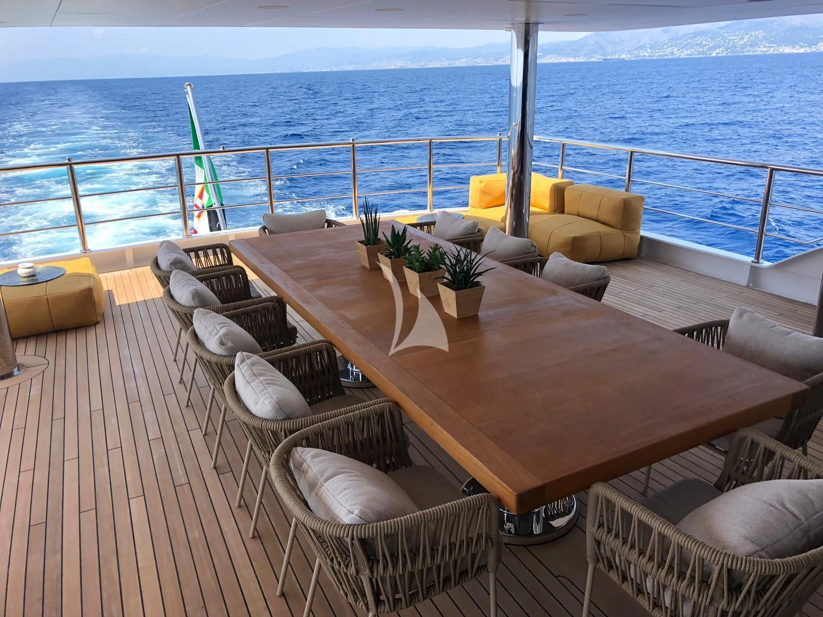 a table with chairs on a deck overlooking the ocean aboard R23 Yacht for Charter