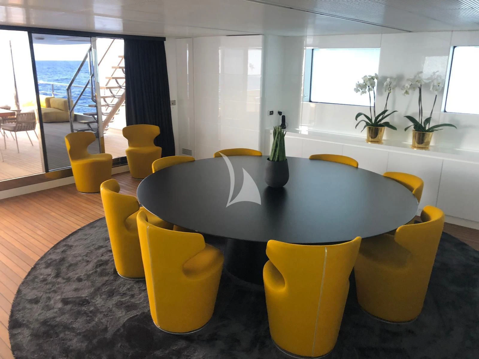 a table with yellow chairs aboard R23 Yacht for Charter