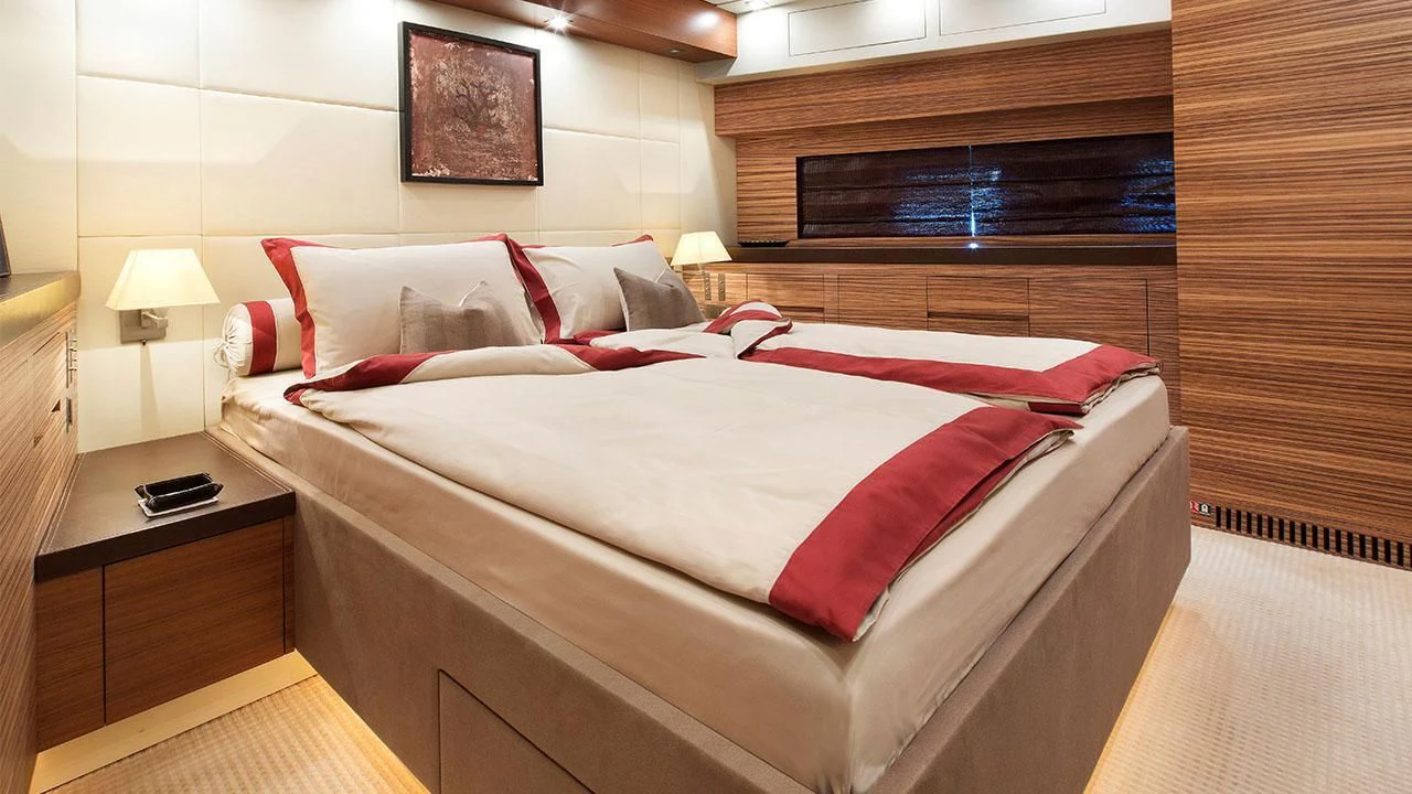 a bed with red pillows aboard ALEON Yacht for Sale
