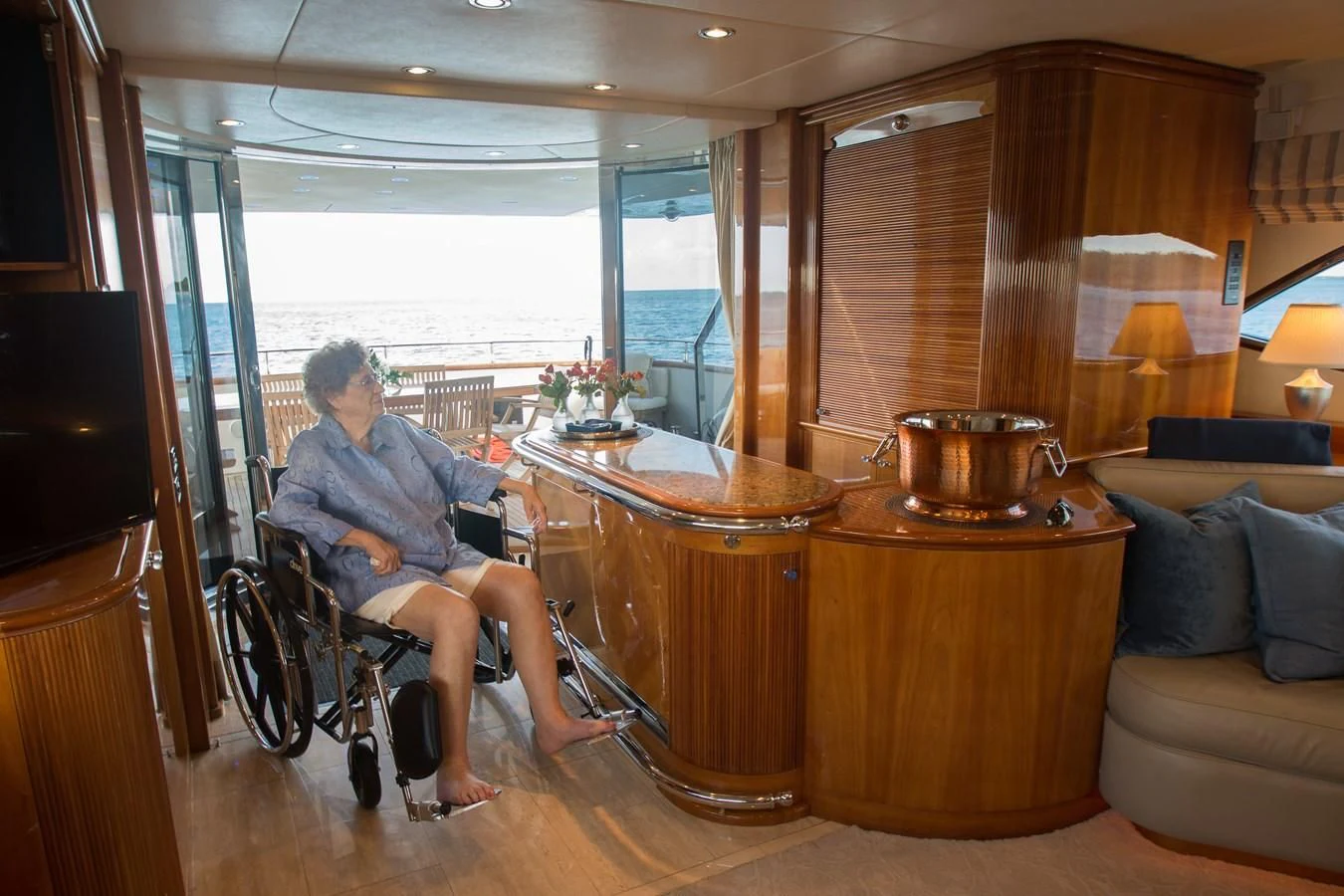 a person in a wheelchair in a living room aboard NO NAME AZIMUT 100 JUMBO Yacht for Sale