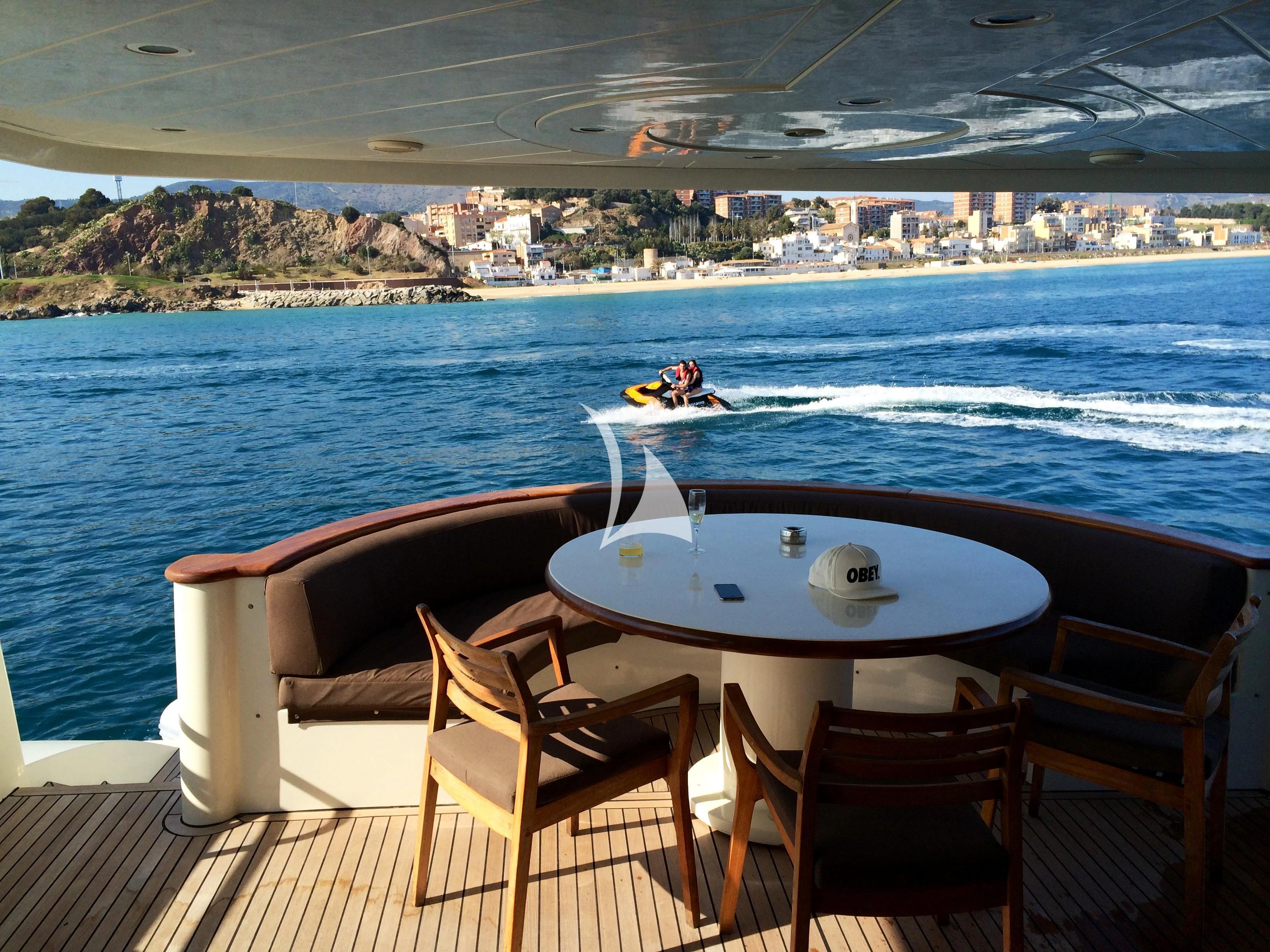 a table and chairs on a deck overlooking a body of water aboard LEIGH Yacht for Sale