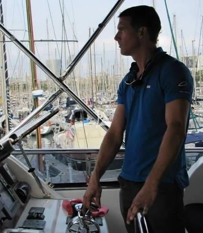a man standing next to a boat aboard LEIGH Yacht for Sale
