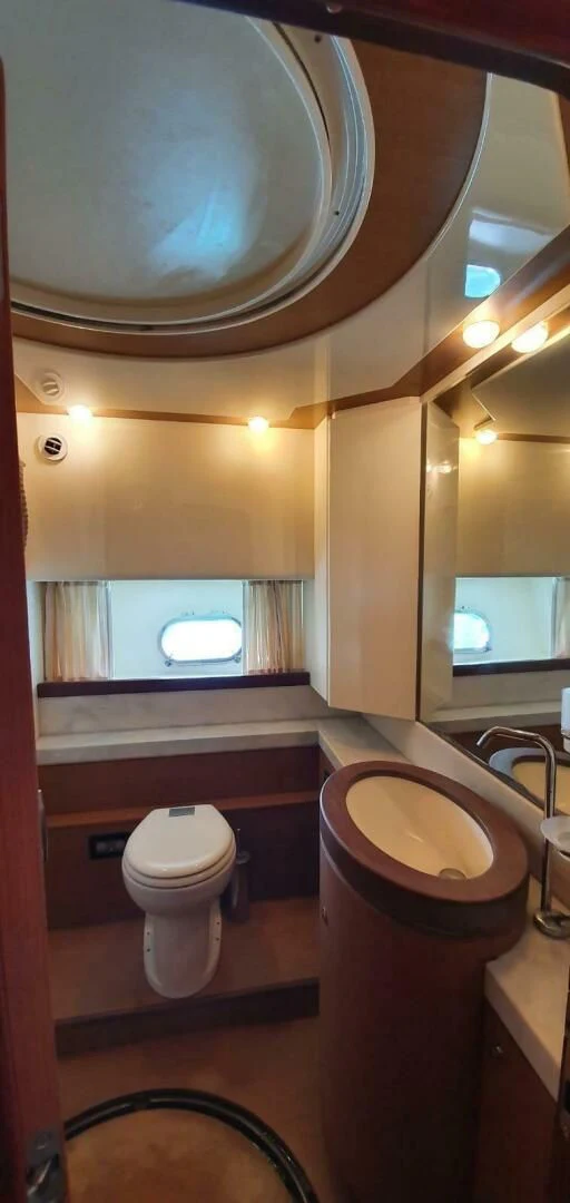 a bathroom with a round mirror aboard SEDROP Yacht for Sale