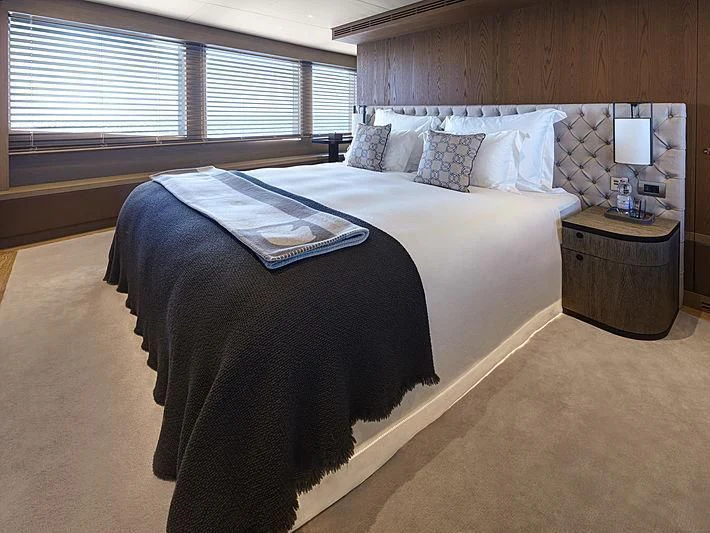 a bed with a blue comforter aboard QUINTET Yacht for Sale
