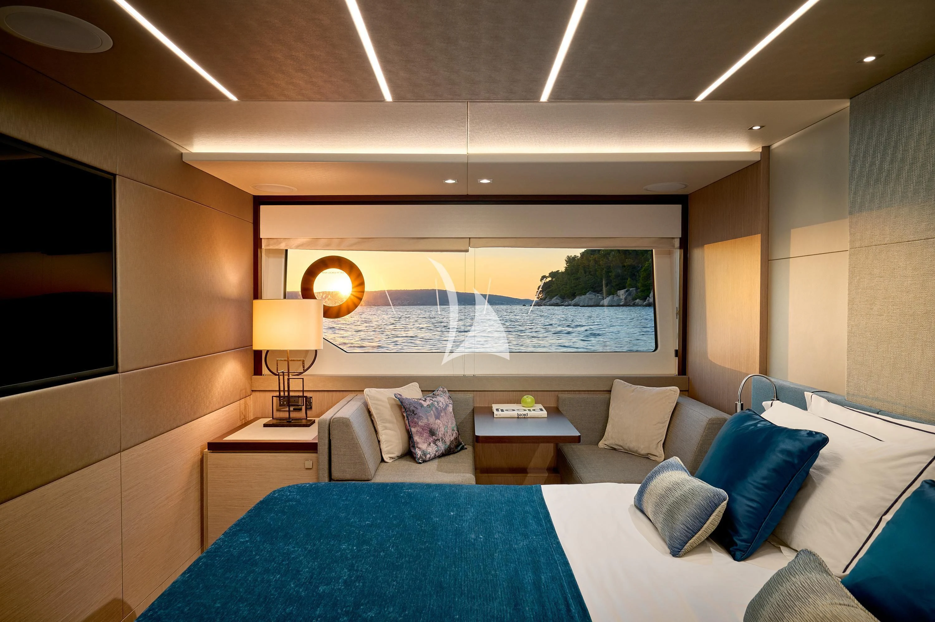 a modern bedroom with a large blue bed and a large painting aboard HIDEAWAY Yacht for Charter