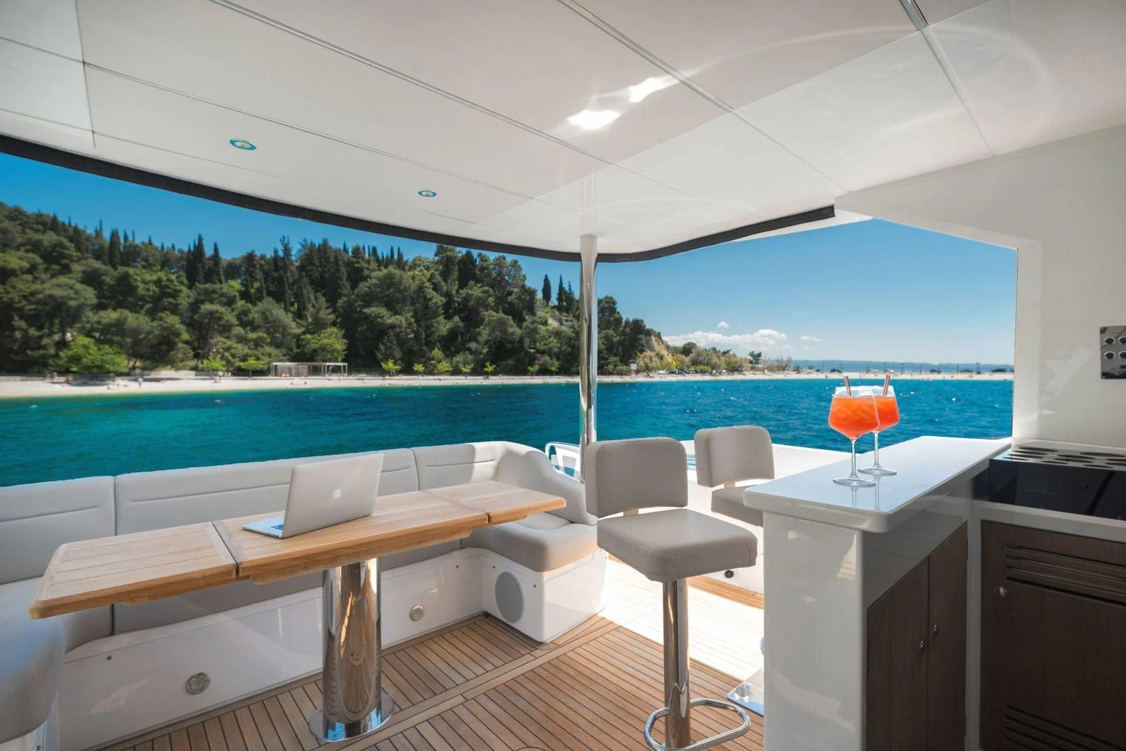 a room with a table and chairs and a laptop on a table aboard HIDEAWAY Yacht for Charter