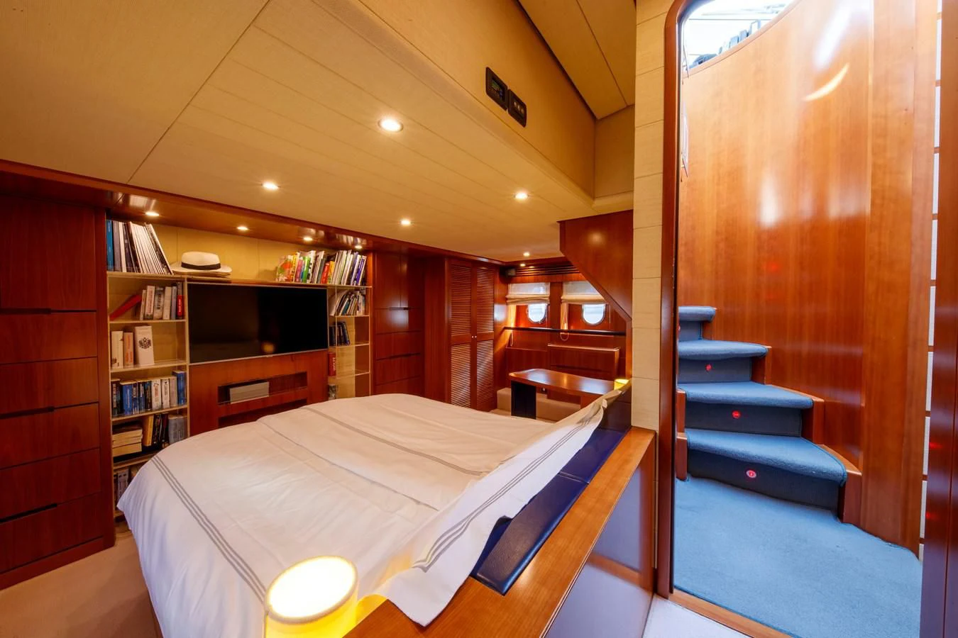 a room with a bed and bookshelves aboard TRUE AUSTRIAN Yacht for Sale