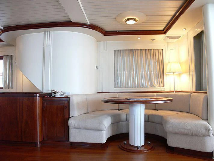 a living room with a table and couches aboard LADY IN BLUE Yacht for Sale