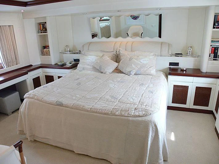 a large white bed with a white comforter and a white bed spread aboard LADY IN BLUE Yacht for Sale
