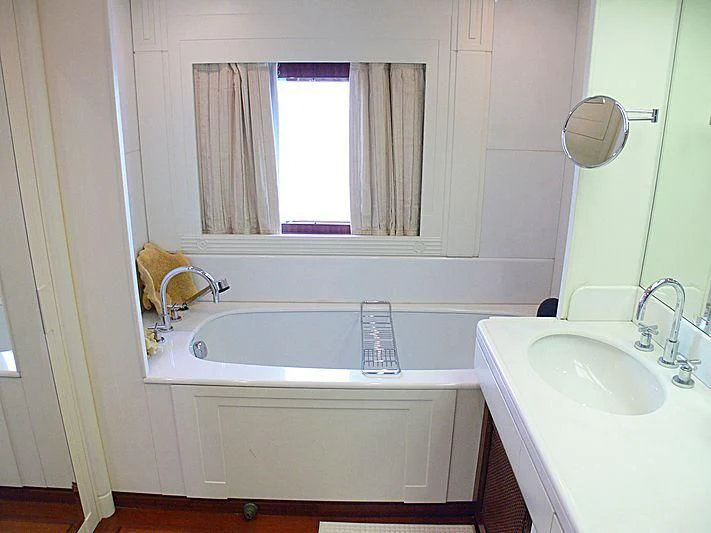 a bathroom with a tub sink and a mirror aboard LADY IN BLUE Yacht for Sale