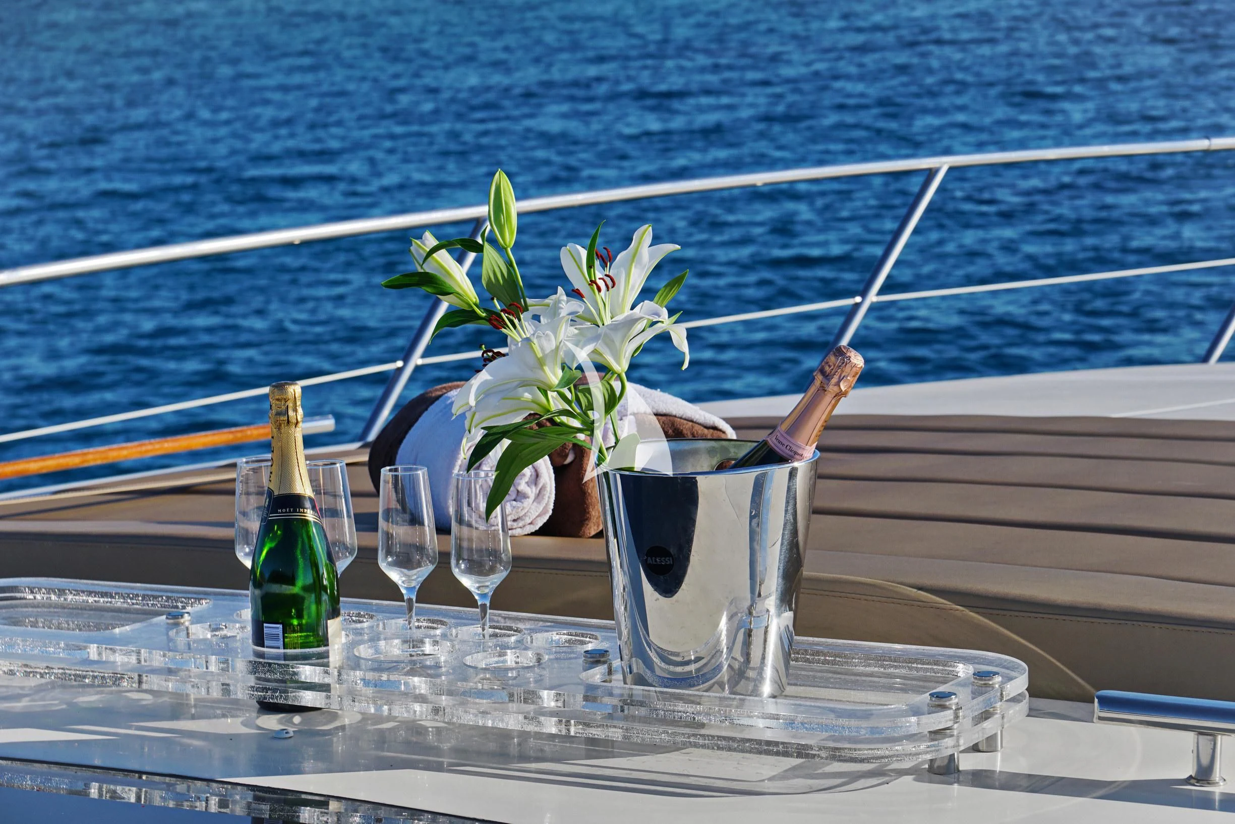 a vase with flowers and a bottle of wine on a table aboard SEA U Yacht for Charter
