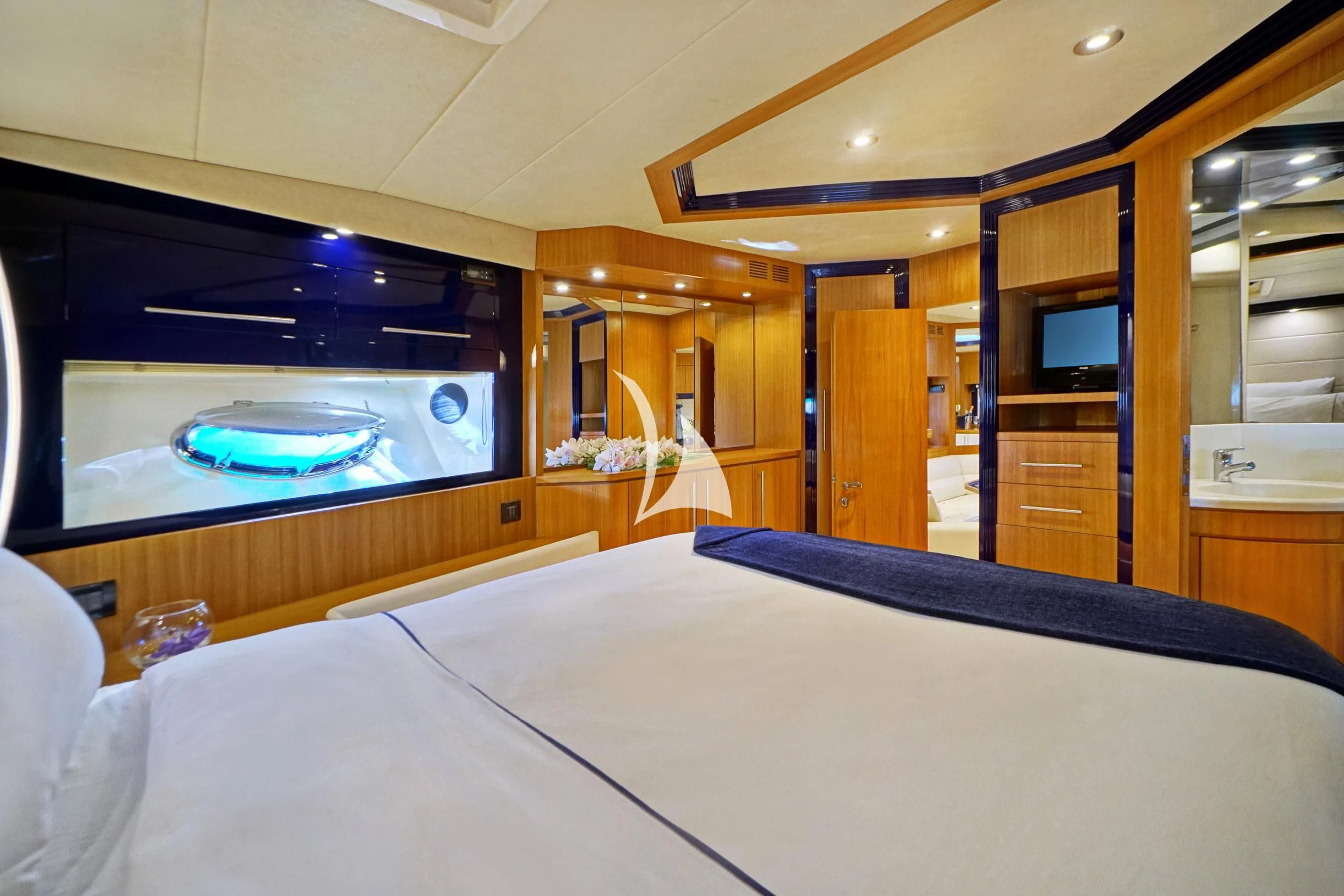 a room with a bed and a television aboard SEA U Yacht for Charter