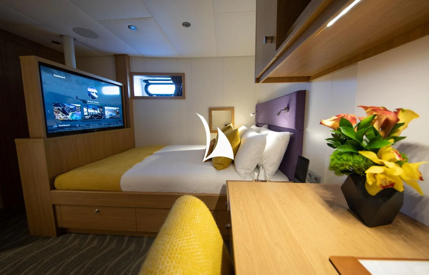 a hotel room with a tv and a bed aboard GAME CHANGER Yacht for Sale