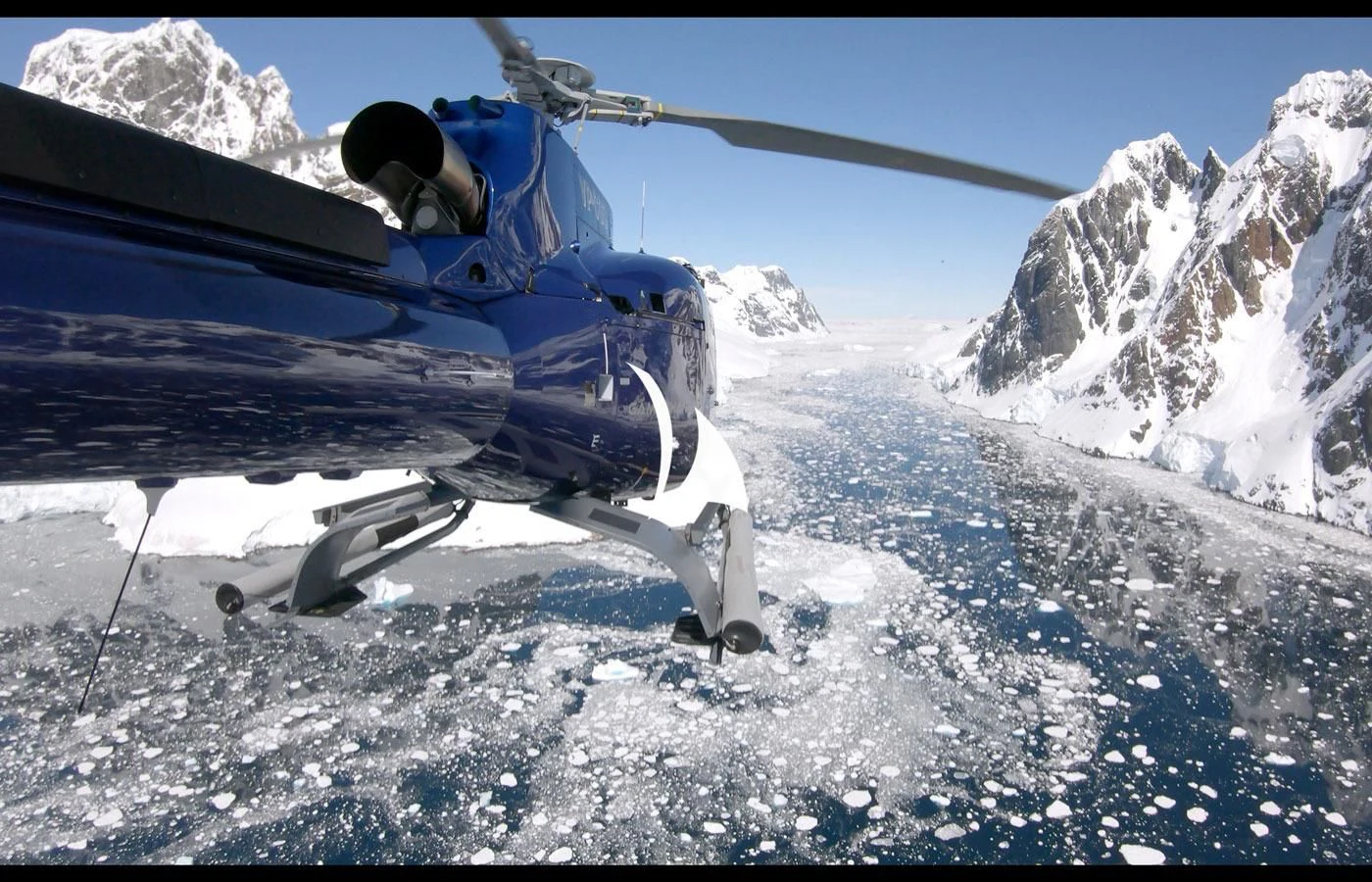 a person in a blue jacket in a snowy mountain aboard GAME CHANGER Yacht for Sale