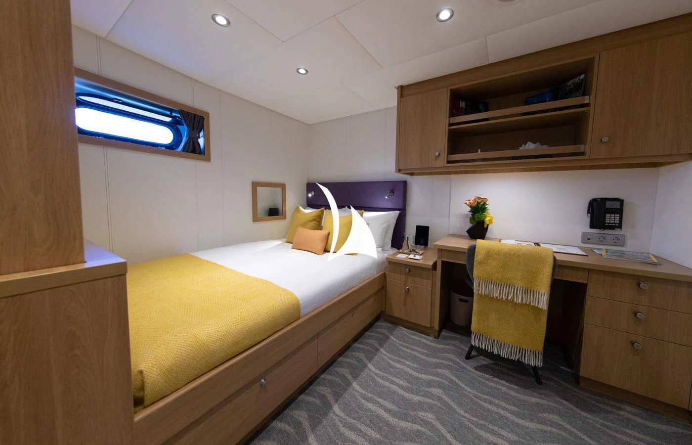 a bedroom with a bed and a desk aboard GAME CHANGER Yacht for Sale