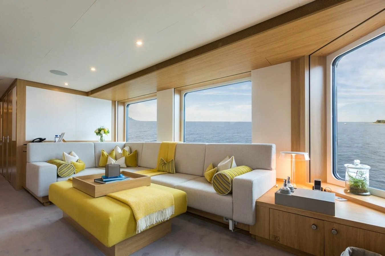 a living room with a yellow couch aboard GAME CHANGER Yacht for Sale