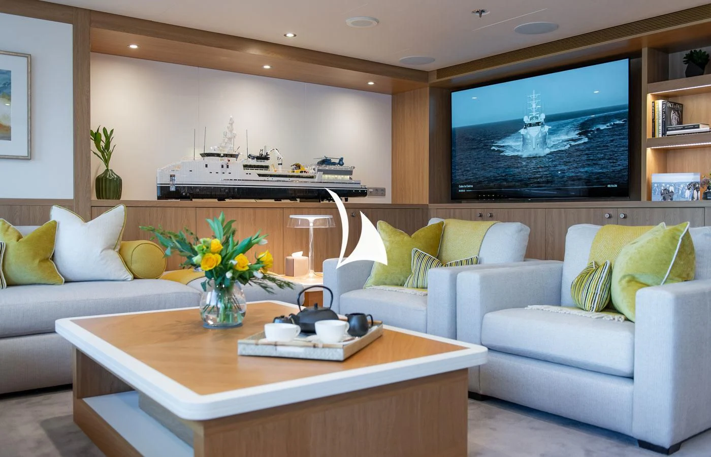 a living room with a tv and a table aboard GAME CHANGER Yacht for Sale