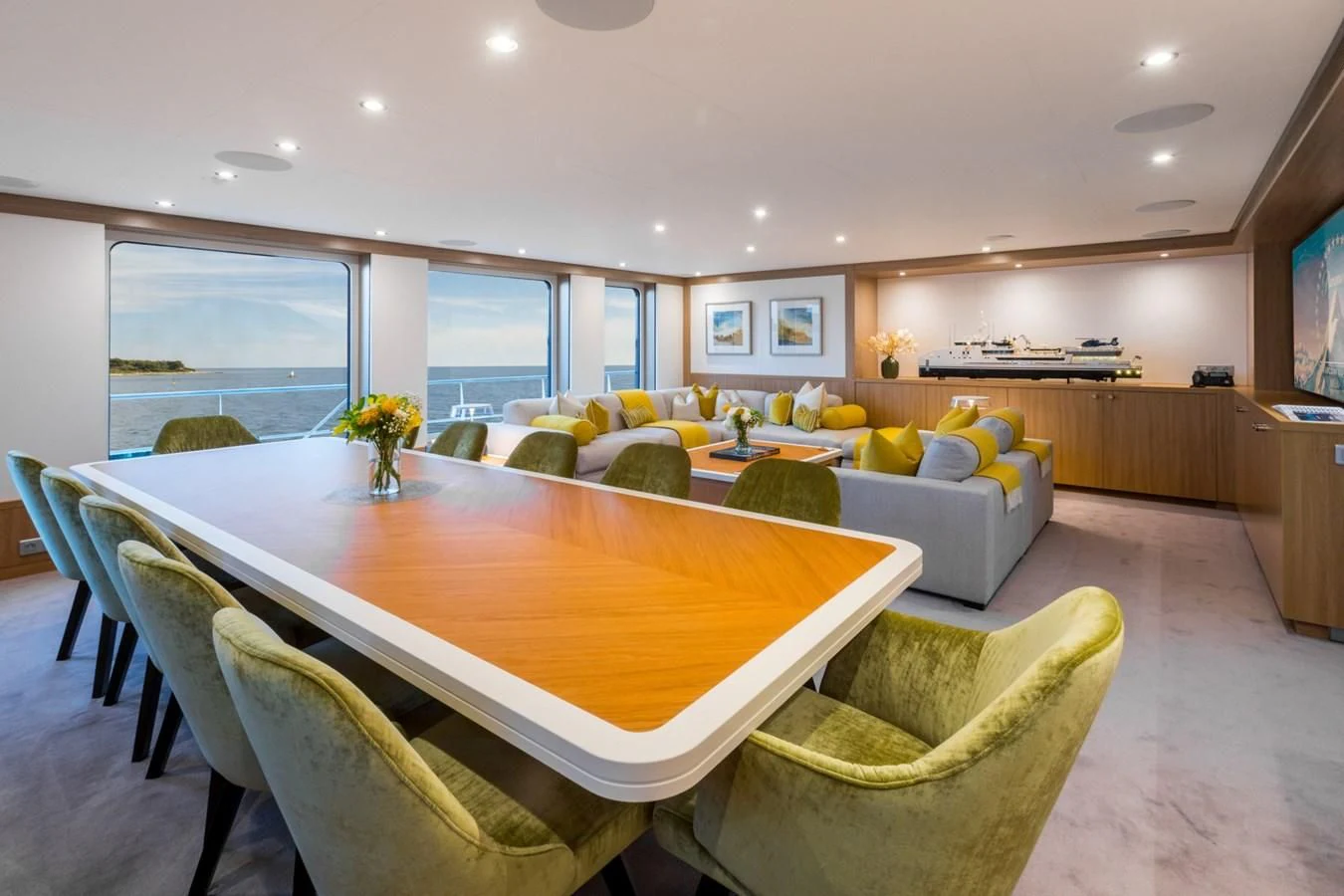 a large living room with a table and chairs aboard GAME CHANGER Yacht for Sale