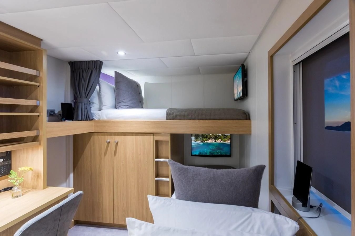 a room with a bed and a tv on the wall aboard GAME CHANGER Yacht for Sale