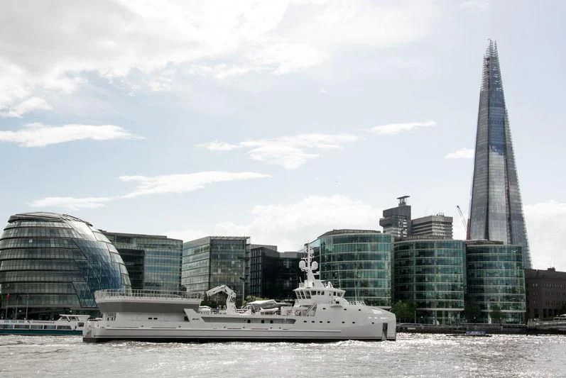 a boat in the water with a city in the background aboard GAME CHANGER Yacht for Sale