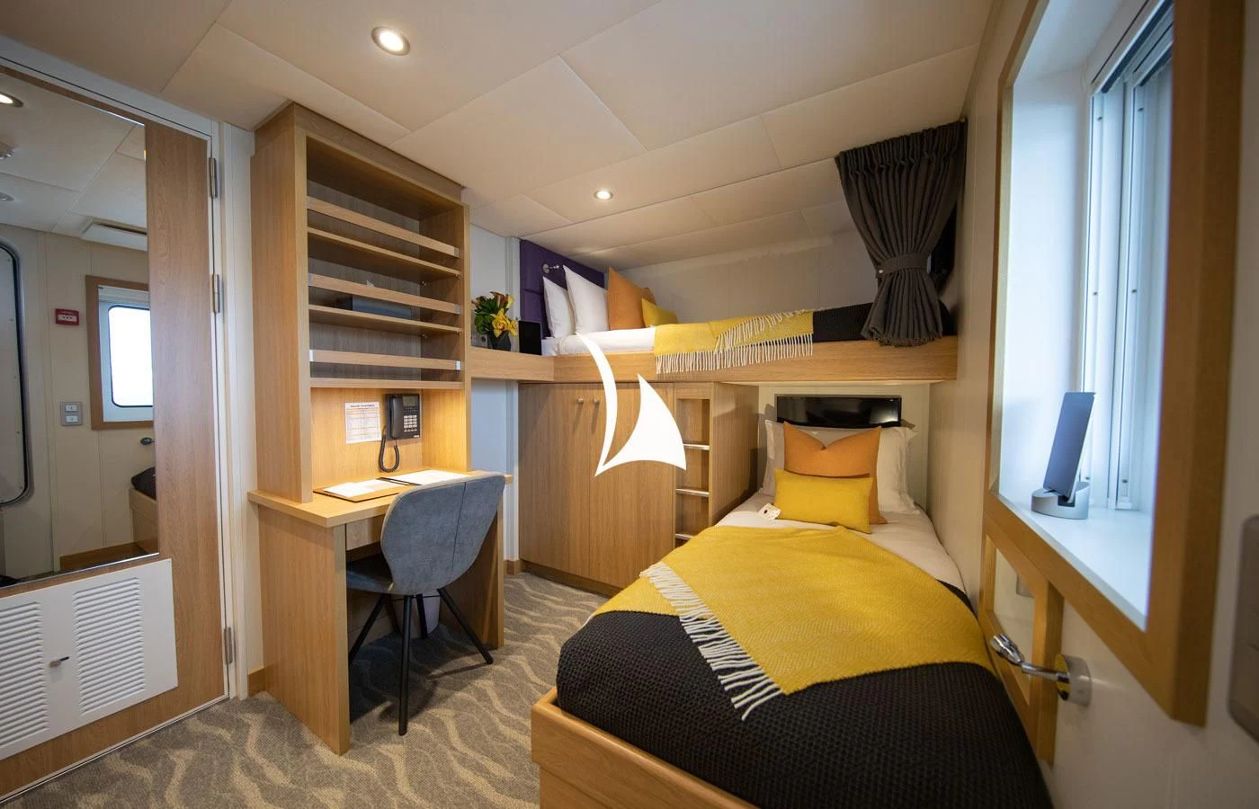 a bedroom with a bed and desk aboard GAME CHANGER Yacht for Sale