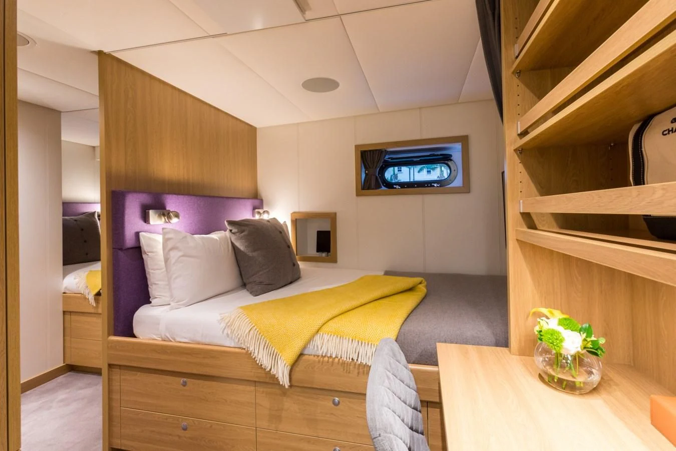 a bedroom with a bed and a tv on the wall aboard GAME CHANGER Yacht for Sale