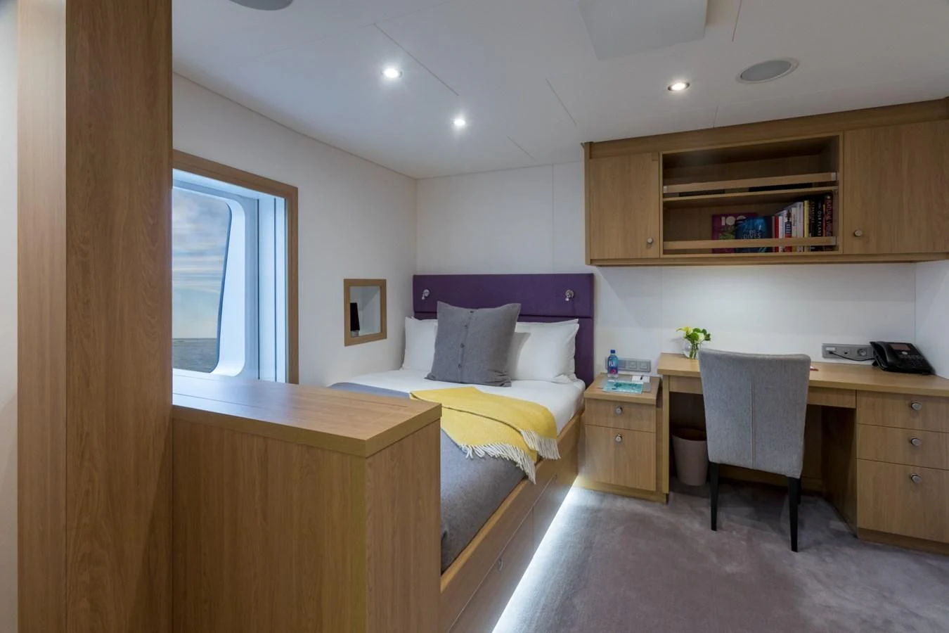 a bedroom with a desk and a bed aboard GAME CHANGER Yacht for Sale