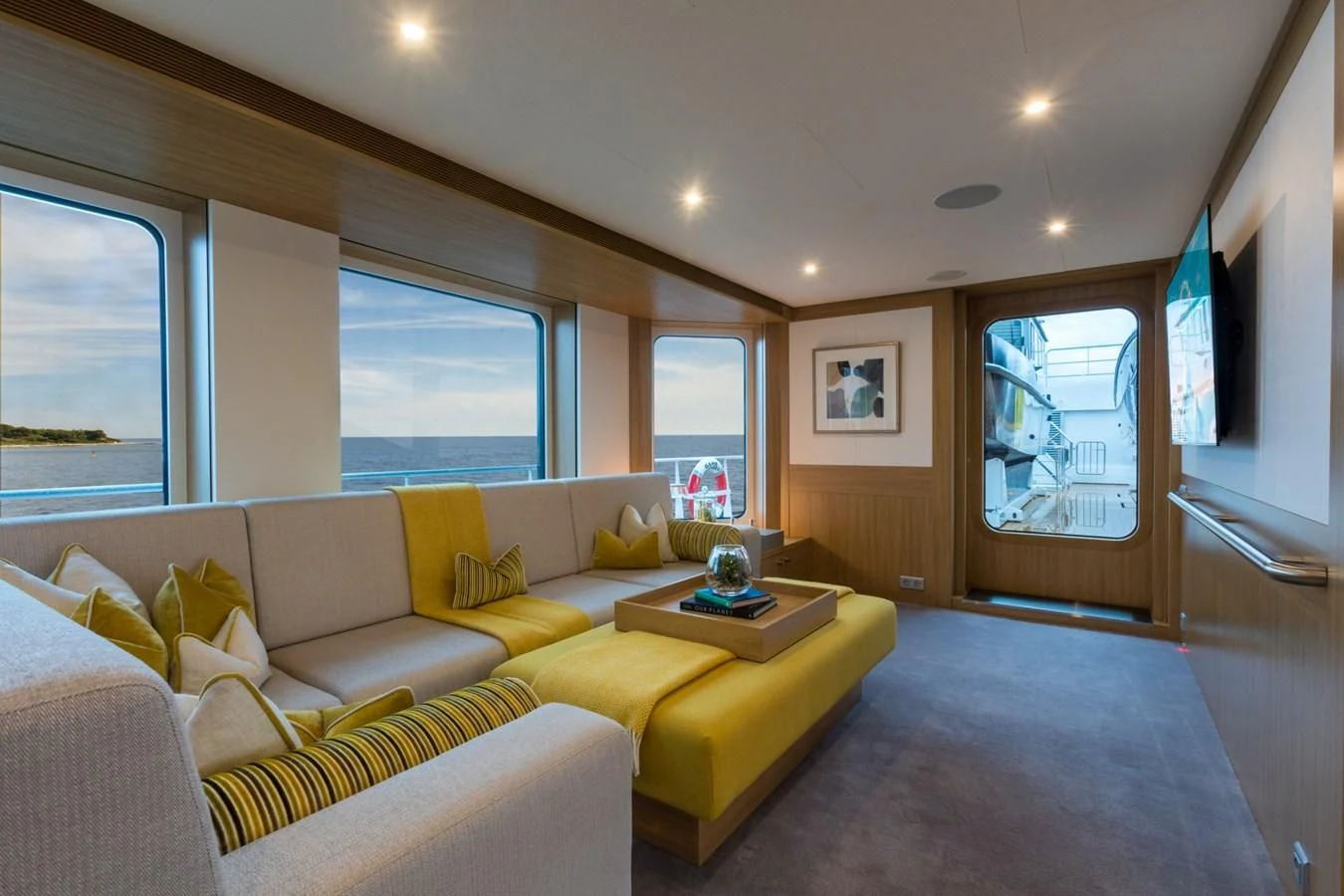 a living room with yellow couches aboard GAME CHANGER Yacht for Sale