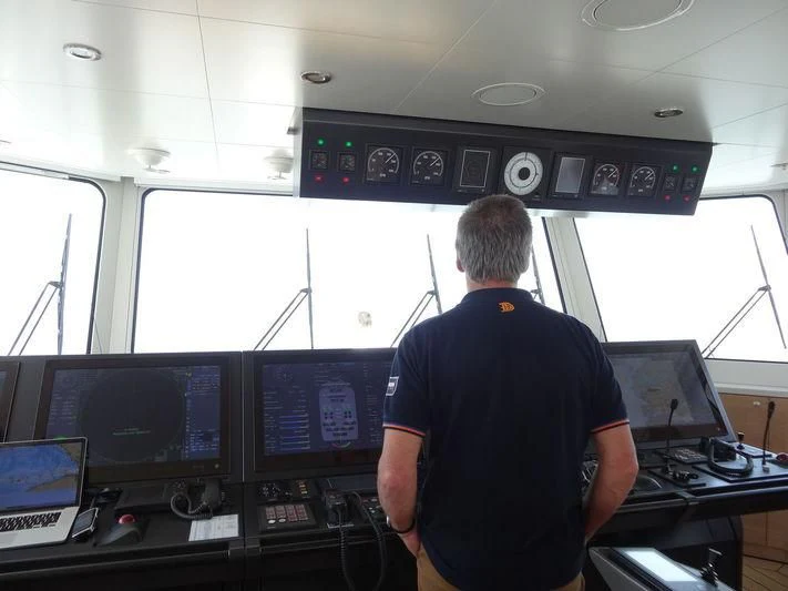 a man standing in front of a control panel aboard GAME CHANGER Yacht for Sale
