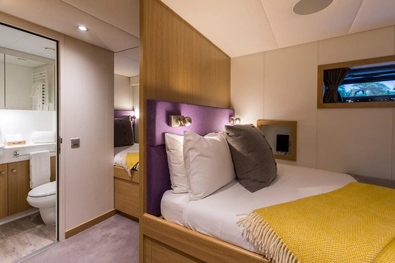 a bedroom with a bed and a tv on the wall aboard GAME CHANGER Yacht for Sale