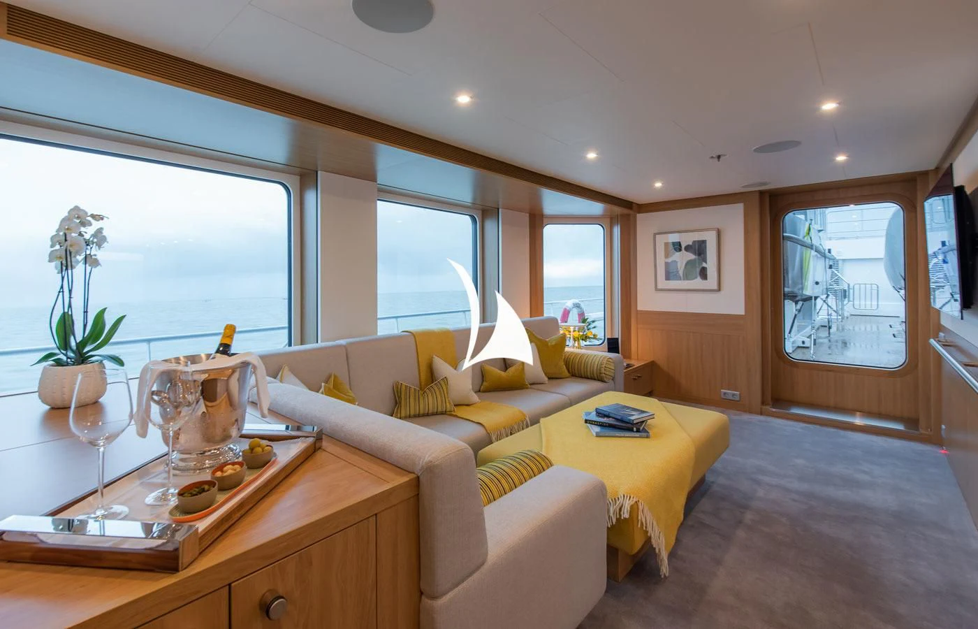 a living room with a yellow couch aboard GAME CHANGER Yacht for Sale
