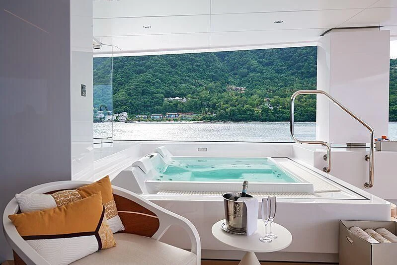 a table with a coffee mug on it and a window with a view of a city aboard ARTEFACT Yacht for Sale